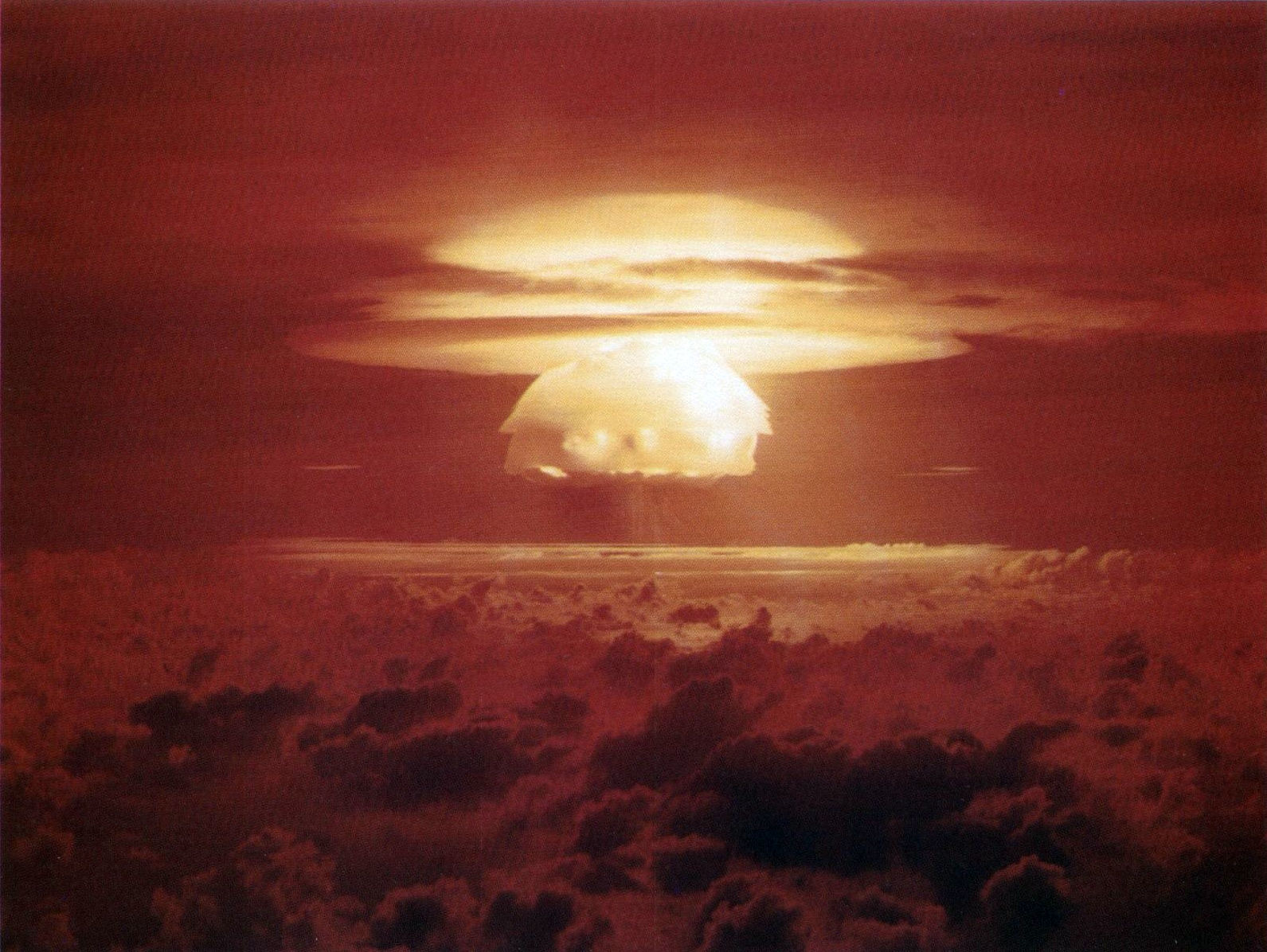 The Castle Bravo cloud over Bikini, a bright dome above a wide flat stem, under a red sky, seen from above the clouds