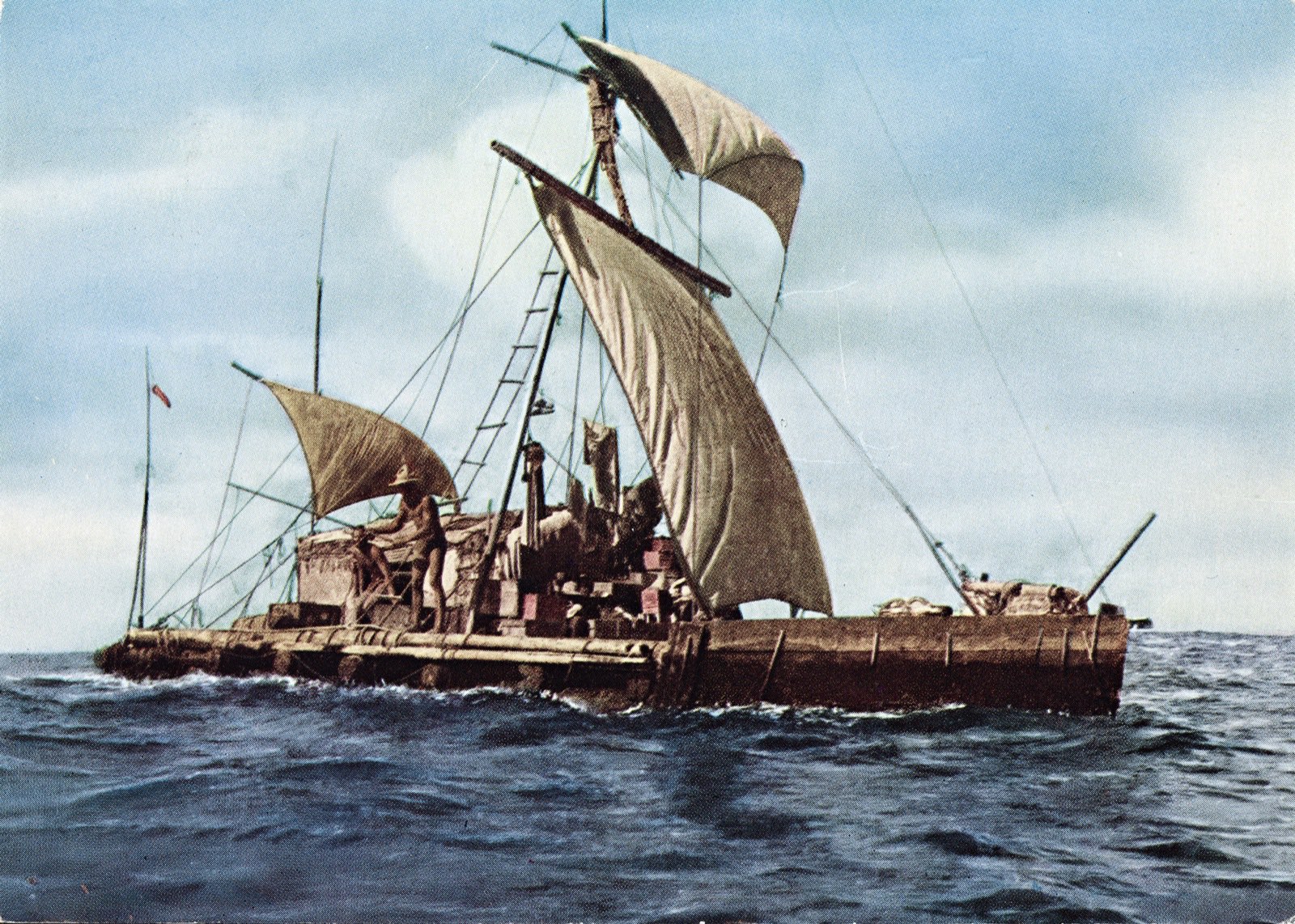 A balsa raft under full sail on a blue sea, its square mainsail and a small topsail drawing, a bamboo hut amidships and a man in a straw hat standing at the steering oar on the stern