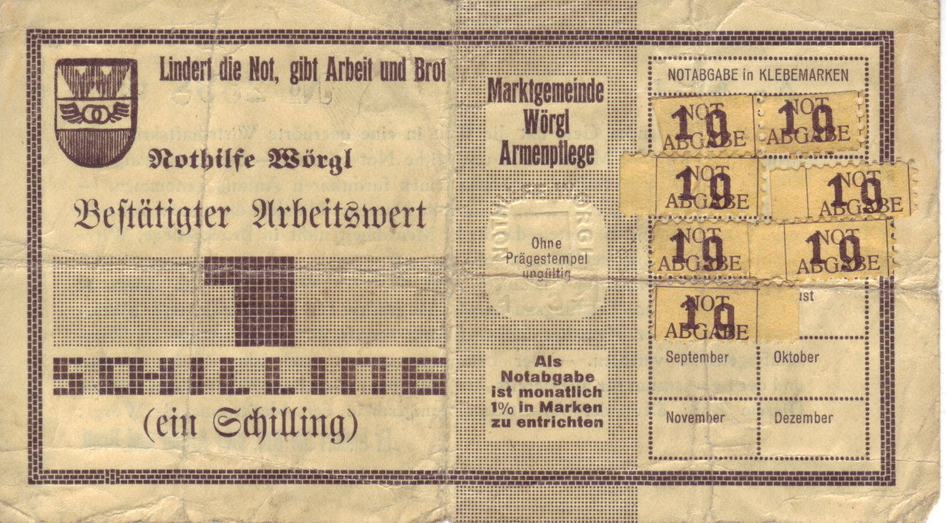 A yellow one-schilling labour certificate of Wörgl with the town arms, the slogan, the embossed control stamp and a grid of twelve monthly fields, seven of them carrying one-groschen stamps